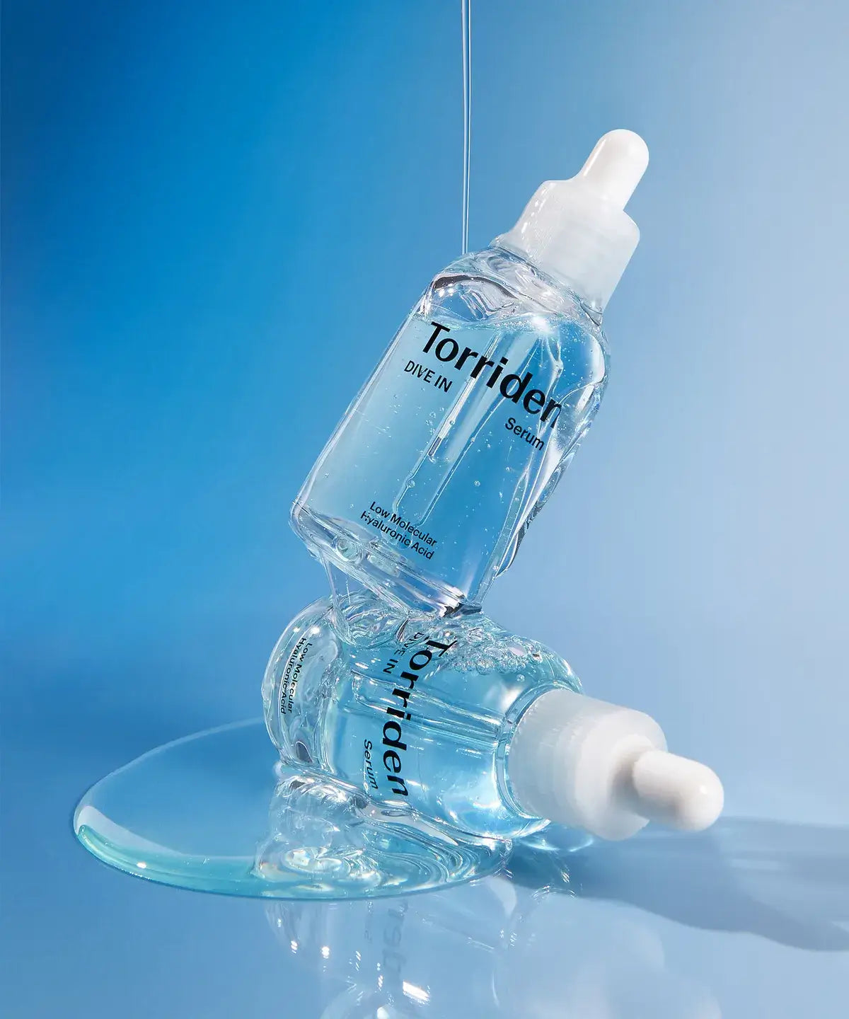 Torriden Dive-In Serum bottles on a blue background, showcasing hydrating ampoule packaging.