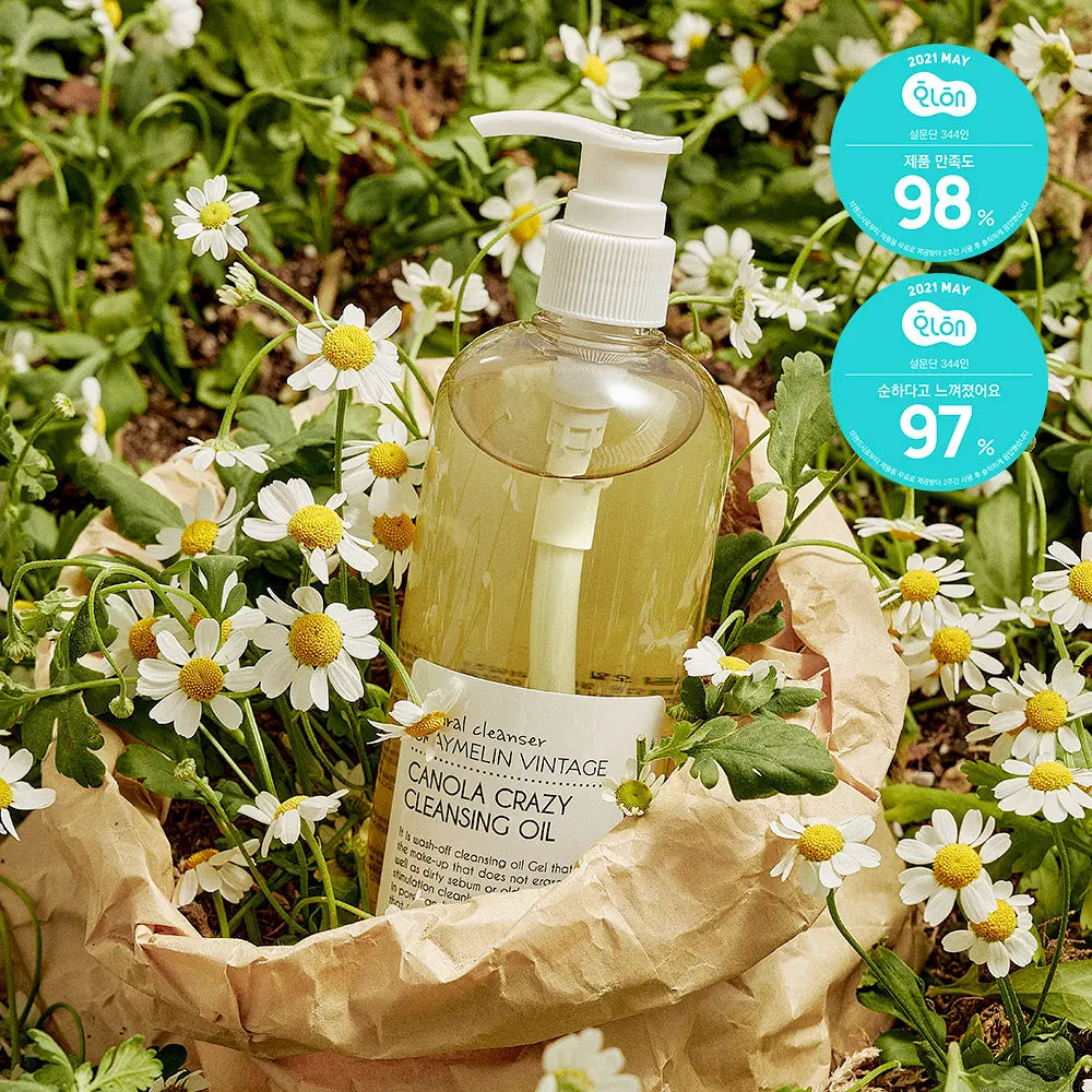 GRAYMELIN Canola Crazy Cleansing Oil bottle surrounded by flowers, showcasing Korean cleansing oil for makeup removal.