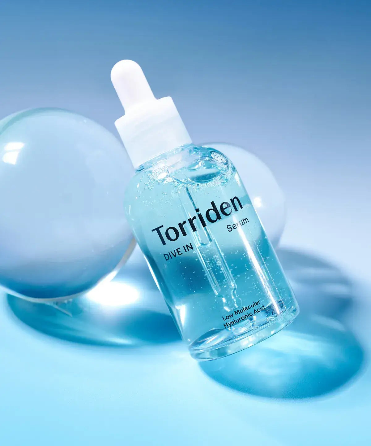 Torriden Dive-In Serum Hydrating Ampoule on a blue background with bubbles, highlighting its lightweight hyaluronic acid formula.